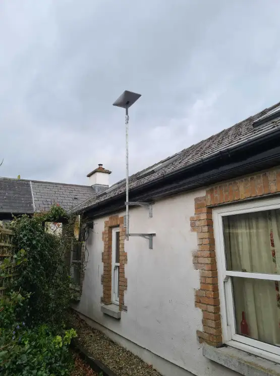 Modern Starlink wifi receiver installed on the wall of a country cottage